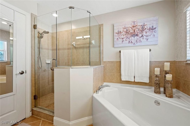 bathroom with a garden tub, a stall shower, tile patterned floors, and plenty of natural light