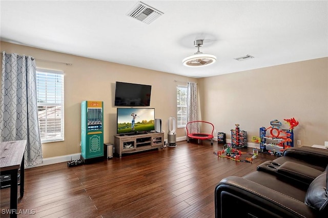 living area with visible vents, hardwood / wood-style flooring, and baseboards