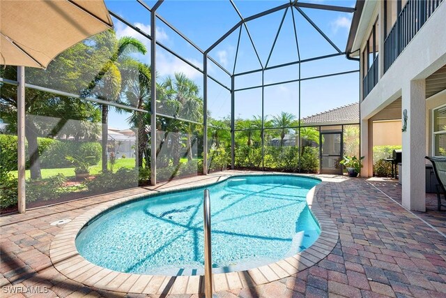 pool with a lanai and a patio area