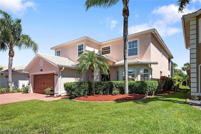 mediterranean / spanish-style home with stucco siding, a tiled roof, driveway, a front lawn, and an attached garage