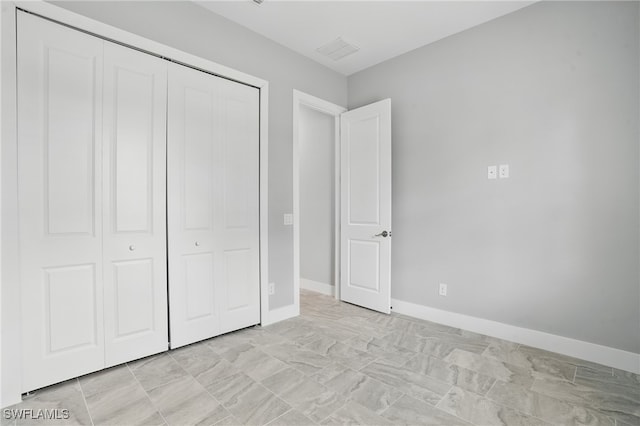 3906 E 10th St, Lehigh Acres, FL 33972 - unfurnished bedroom with a closet and baseboards