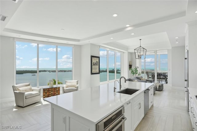 4971 Bonita Bay Blvd Unit Ph2503, Bonita Springs, FL 34134 - kitchen with a tray ceiling, a chandelier, appliances with stainless steel finishes, a water view, and light countertops