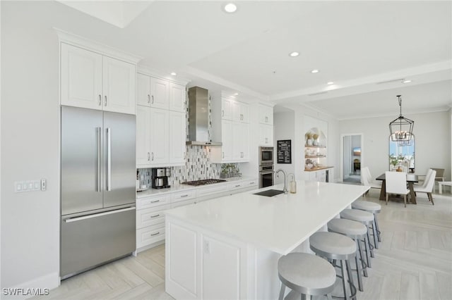 4971 Bonita Bay Blvd Unit Ph2503, Bonita Springs, FL 34134 - kitchen featuring built in appliances, wall chimney exhaust hood, an island with sink, white cabinetry, and recessed lighting