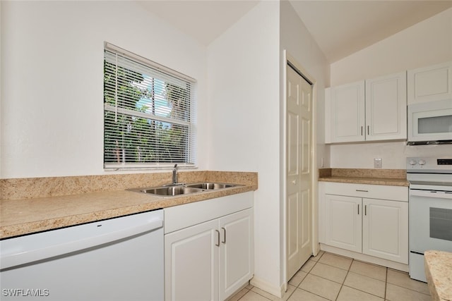 kitchen featuring a sink, white cabinets, white appliances, and light tile patterned flooring