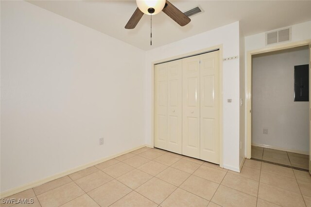 unfurnished bedroom featuring light tile patterned flooring, baseboards, visible vents, and a closet