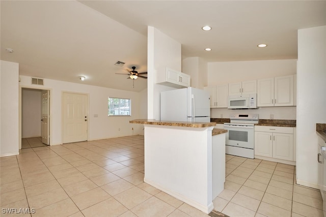 kitchen with white appliances, vaulted ceiling, light tile patterned floors, and visible vents