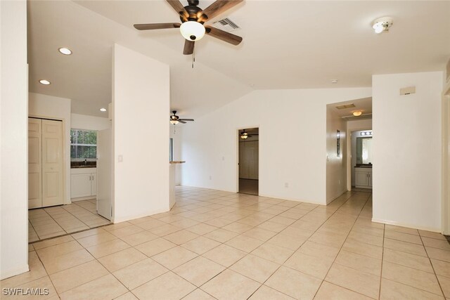 empty room featuring visible vents, ceiling fan, light tile patterned floors, and vaulted ceiling