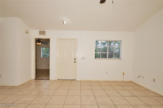 empty room featuring a ceiling fan, visible vents, and light tile patterned floors
