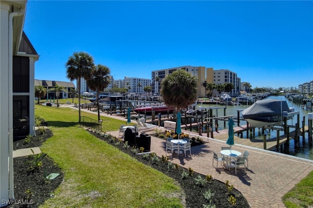 view of dock with a lawn, a water view, and boat lift
