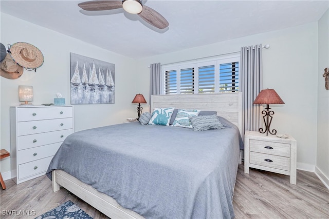 bedroom with a ceiling fan, baseboards, and wood finished floors