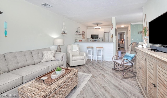 living room with light wood-type flooring and visible vents