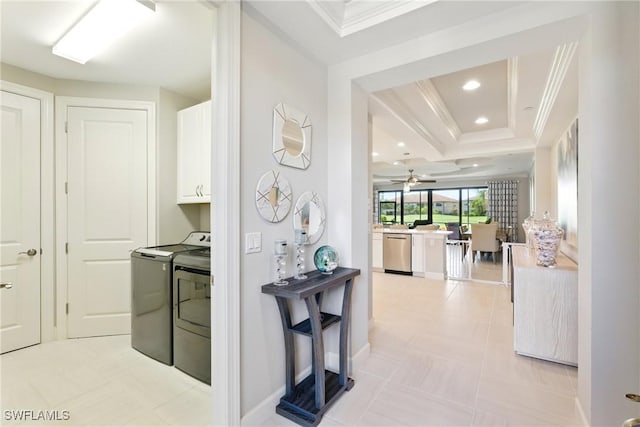 hallway featuring crown molding, a raised ceiling, recessed lighting, and washing machine and clothes dryer