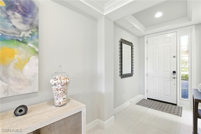 entryway with baseboards, crown molding, and a tray ceiling