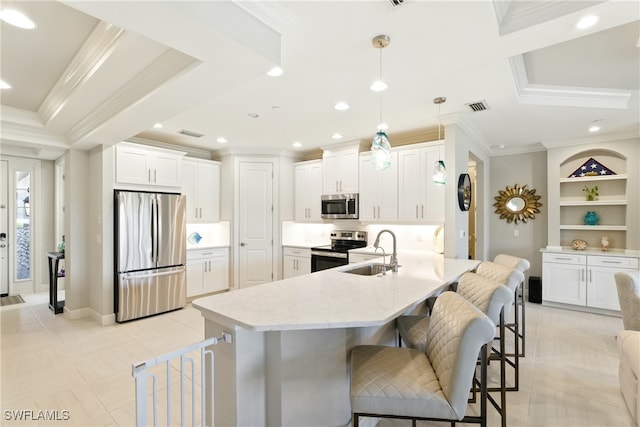 kitchen with a kitchen bar, visible vents, appliances with stainless steel finishes, a sink, and ornamental molding