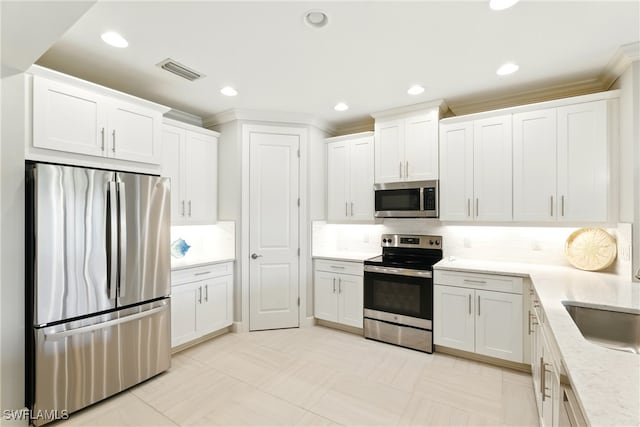 kitchen with visible vents, decorative backsplash, light countertops, white cabinets, and stainless steel appliances