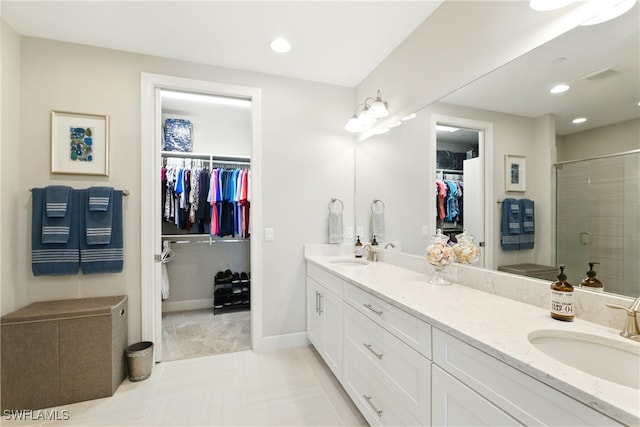 bathroom with double vanity, recessed lighting, a shower stall, and a sink