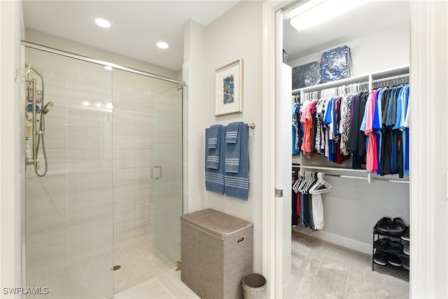 full bathroom featuring recessed lighting, a spacious closet, and a shower stall