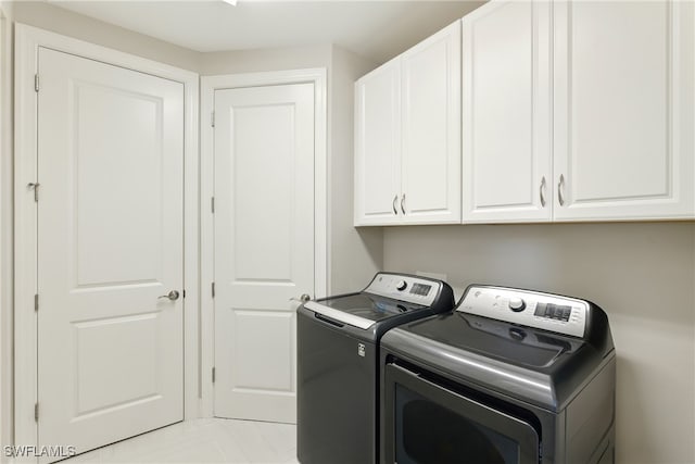 clothes washing area with cabinet space and washing machine and dryer