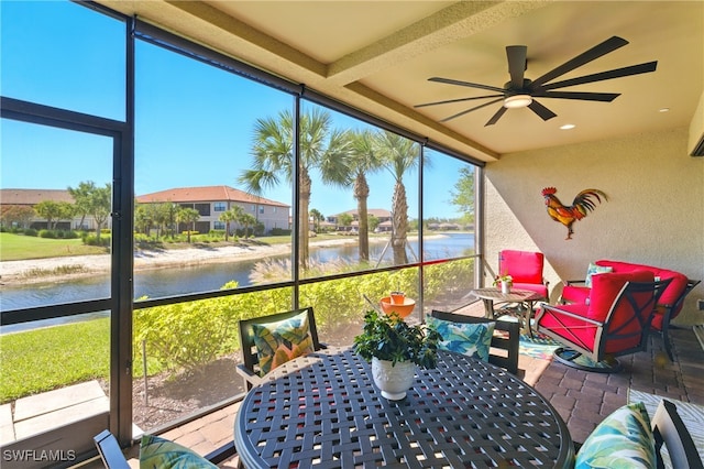 sunroom with a water view, ceiling fan, and outdoor dining space