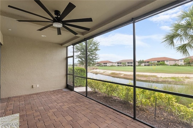 9654 Montelanico Loop Unit 102, Naples, FL 34119 - unfurnished sunroom featuring a ceiling fan and a water view