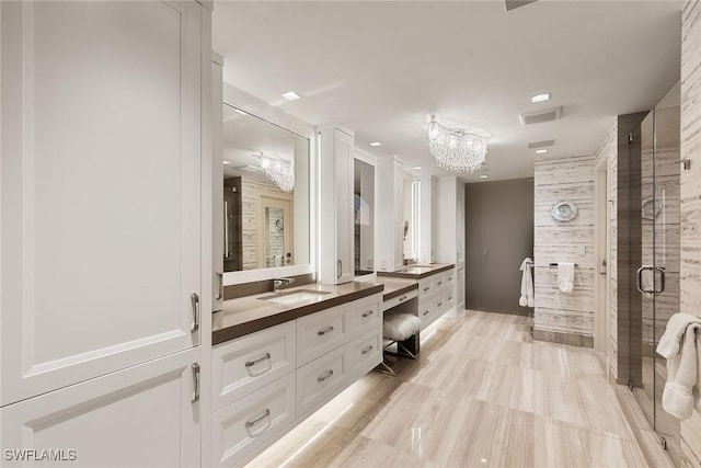 bathroom with visible vents, a shower stall, a chandelier, and vanity