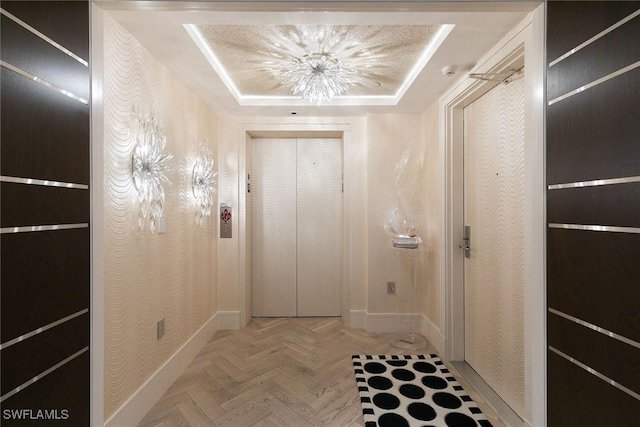 hallway featuring a tray ceiling