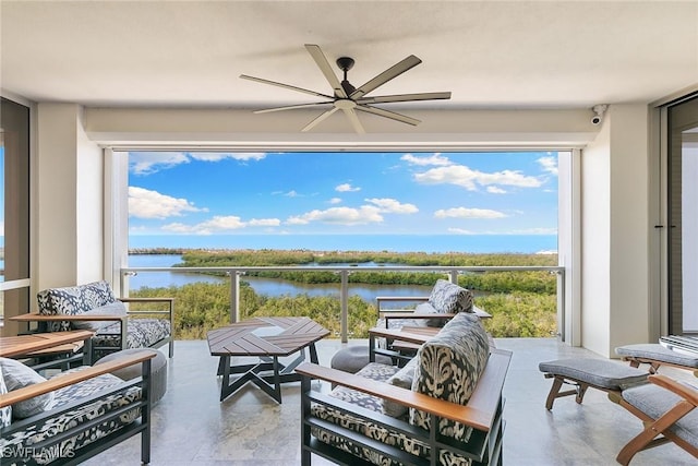view of patio / terrace featuring a balcony, a ceiling fan, and a water view
