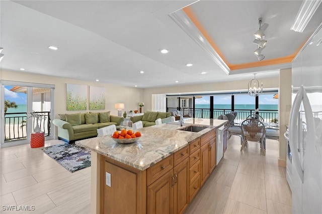 3333 Gulf Shore Blvd N Unit 4, Naples, FL 34103 - kitchen featuring a sink, a tray ceiling, light stone counters, white appliances, and an inviting chandelier