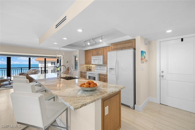 3333 Gulf Shore Blvd N Unit 4, Naples, FL 34103 - kitchen featuring visible vents, brown cabinetry, white appliances, a raised ceiling, and a sink