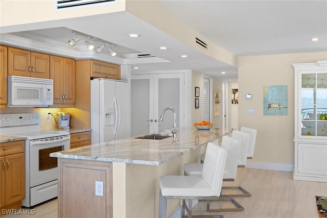 3333 Gulf Shore Blvd N Unit 4, Naples, FL 34103 - kitchen featuring white appliances, light stone counters, visible vents, a sink, and tasteful backsplash