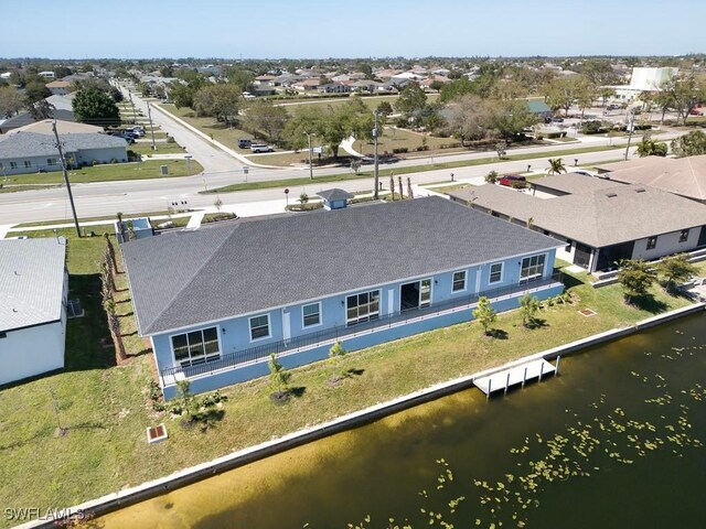 drone / aerial view with a residential view and a water view