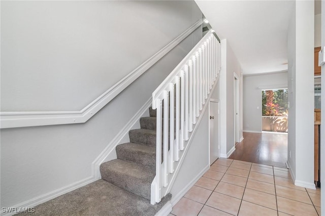 staircase with tile patterned floors and baseboards