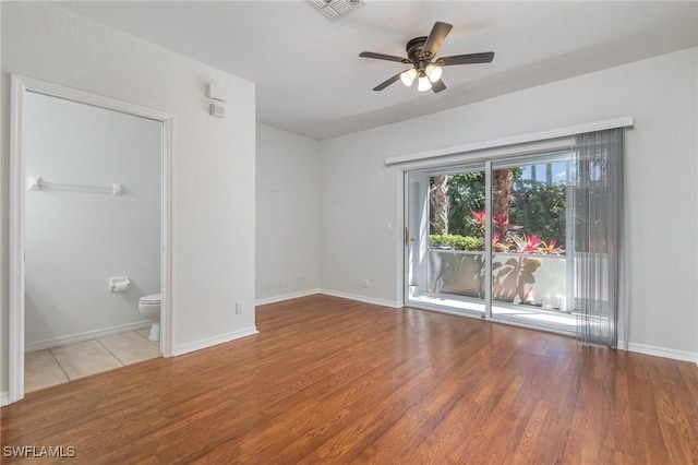 unfurnished room with baseboards, visible vents, wood finished floors, and a ceiling fan