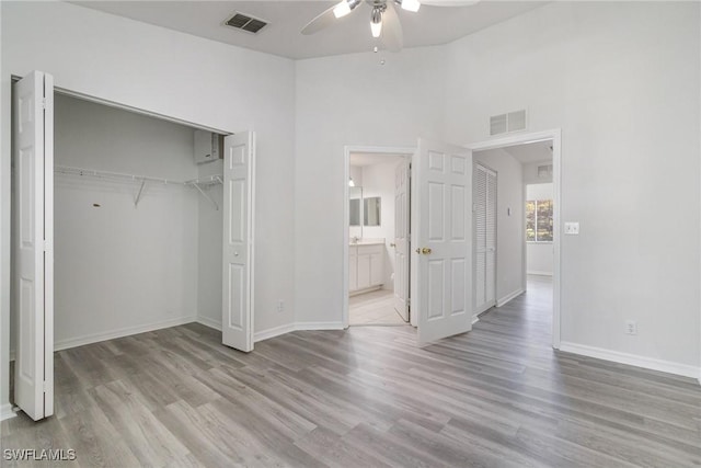 unfurnished bedroom with baseboards, visible vents, a closet, and wood finished floors