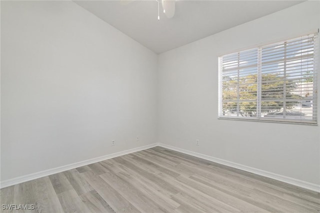 spare room with baseboards, light wood-style floors, and ceiling fan