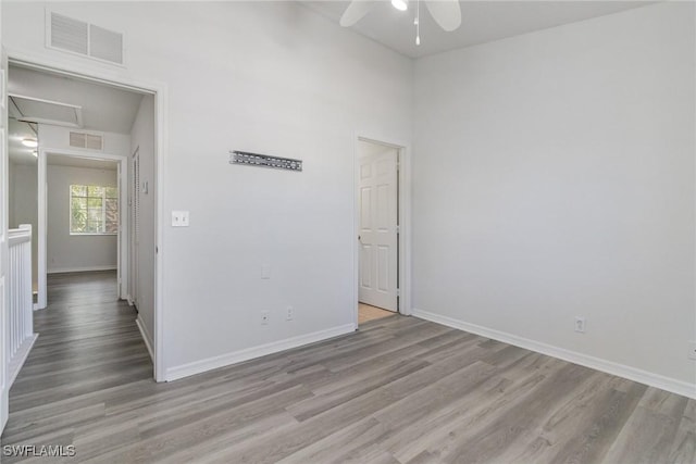 spare room with baseboards, visible vents, wood finished floors, and ceiling fan