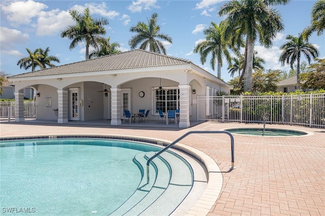 community pool with a community hot tub, a ceiling fan, fence, and a patio