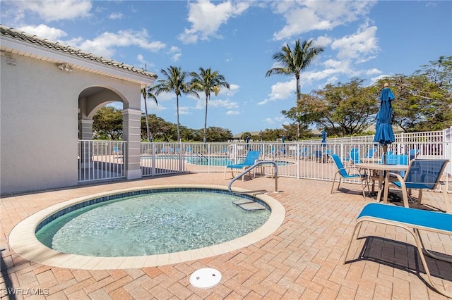 community pool with fence and a patio