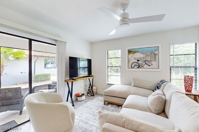 living area featuring baseboards and a ceiling fan