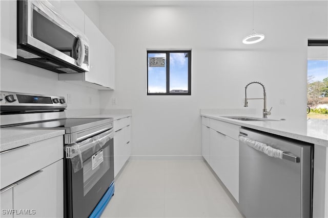 3808 10th St SW, Lehigh Acres, FL 33976 - kitchen featuring a sink, hanging light fixtures, stainless steel appliances, white cabinets, and modern cabinets