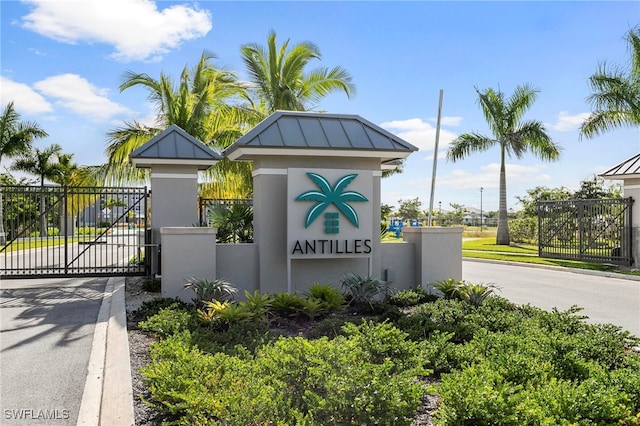 238 Indies Dr E Unit 101, Naples, FL 34114 - community / neighborhood sign featuring a gate, driveway, and fence
