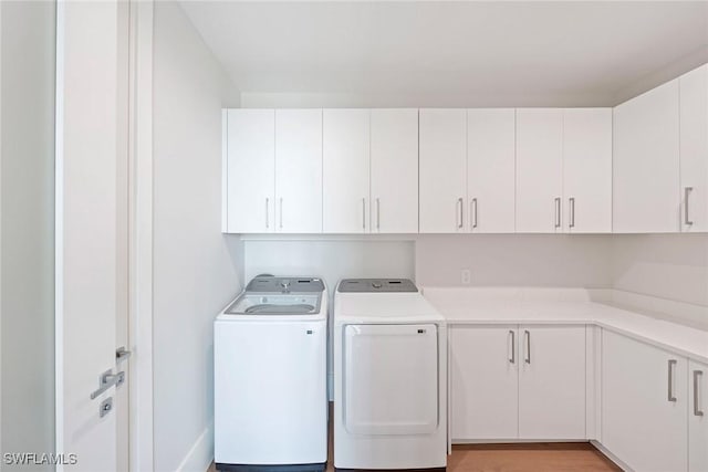 1165 8th St S Unit 202, Naples, FL 34102 - laundry area with cabinet space, washing machine and dryer, and light wood-style floors