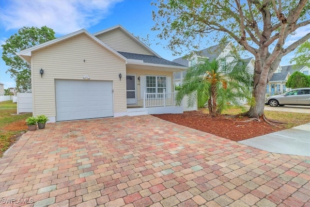 single story home featuring a garage, decorative driveway, and roof with shingles