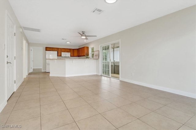 unfurnished living room featuring light tile patterned flooring, baseboards, visible vents, and ceiling fan