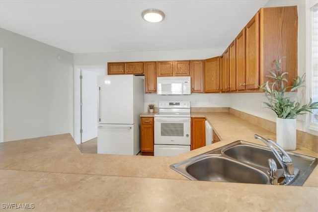 kitchen featuring white appliances, light countertops, brown cabinets, and a sink