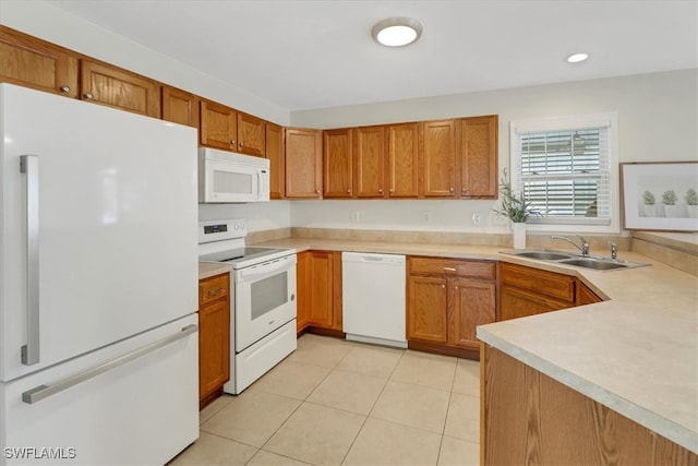 kitchen featuring white appliances, brown cabinetry, light tile patterned flooring, a sink, and light countertops