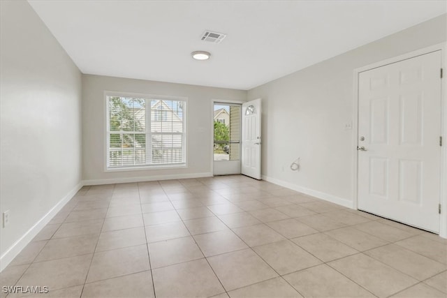 unfurnished room featuring light tile patterned floors, baseboards, and visible vents