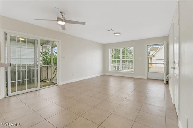 spare room featuring light tile patterned flooring, visible vents, baseboards, and ceiling fan