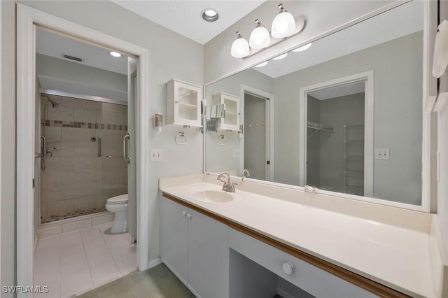529 Mardel Dr Unit 311, Naples, FL 34104 - bathroom featuring toilet, vanity, a stall shower, tile patterned flooring, and a walk in closet