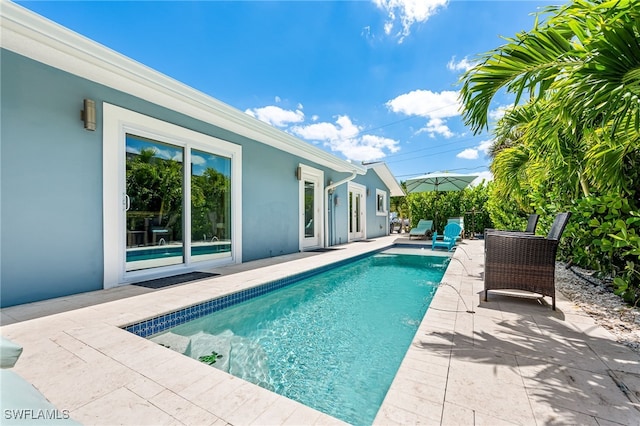 outdoor pool with a patio and fence